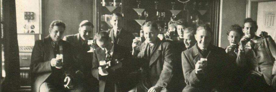 Männergruppe biertrinkend und in geselliger Runde in der Wirtschaft, dabei posierend für's Foto.