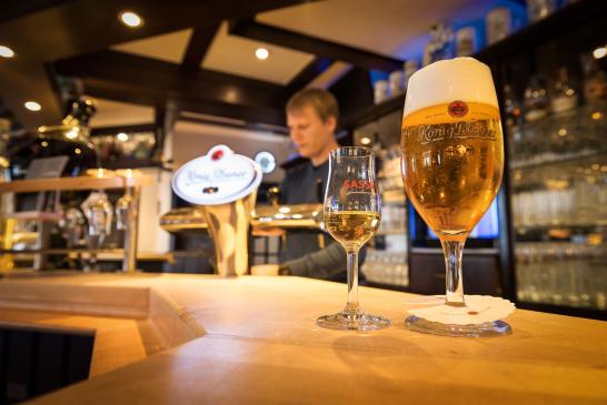Nahaufnahme von der Theke mit einem Glas König Pilsener und ein Likör der Brennerei Sasse